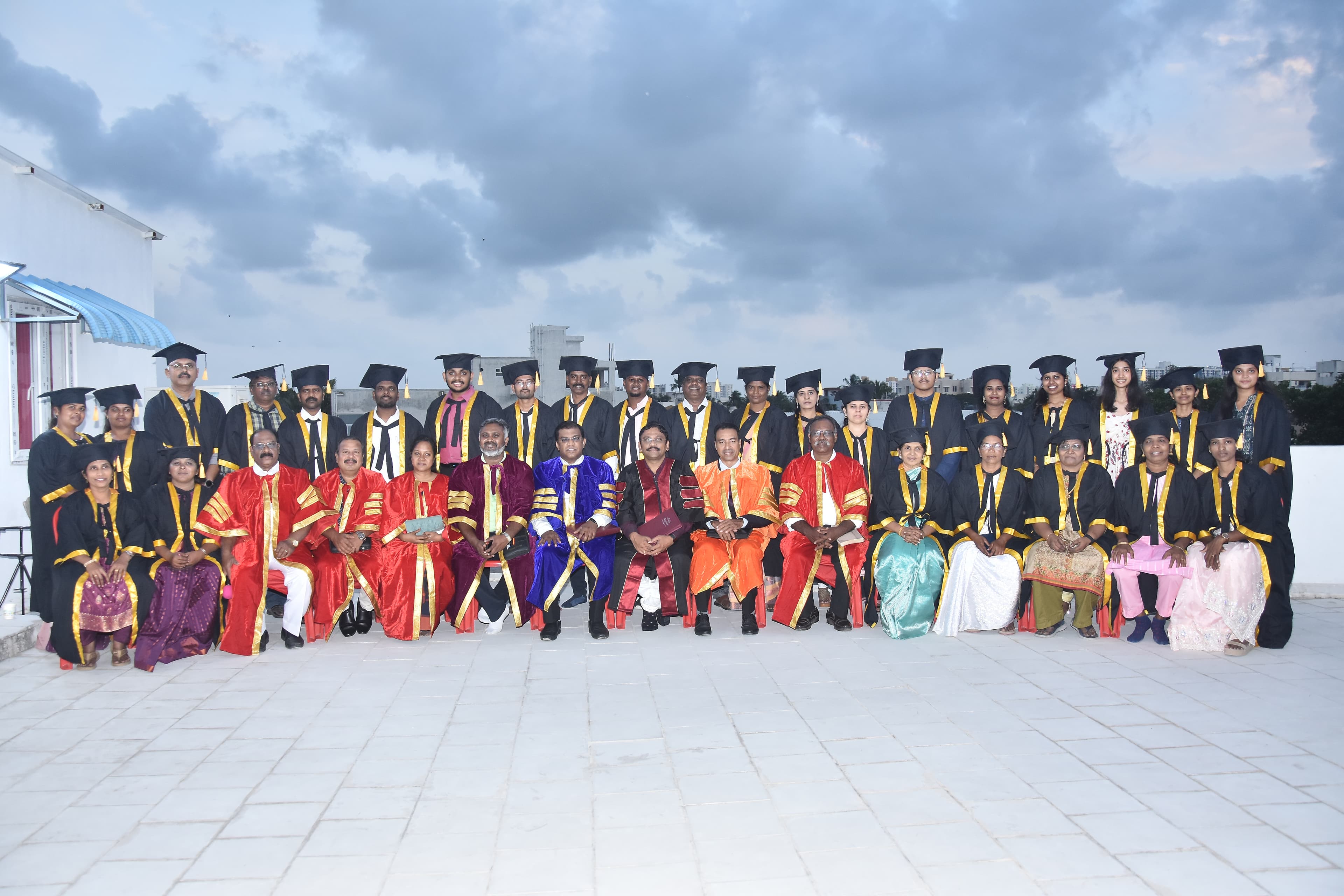 A Bible Institute graduating group photographed on a rooftop terrace.