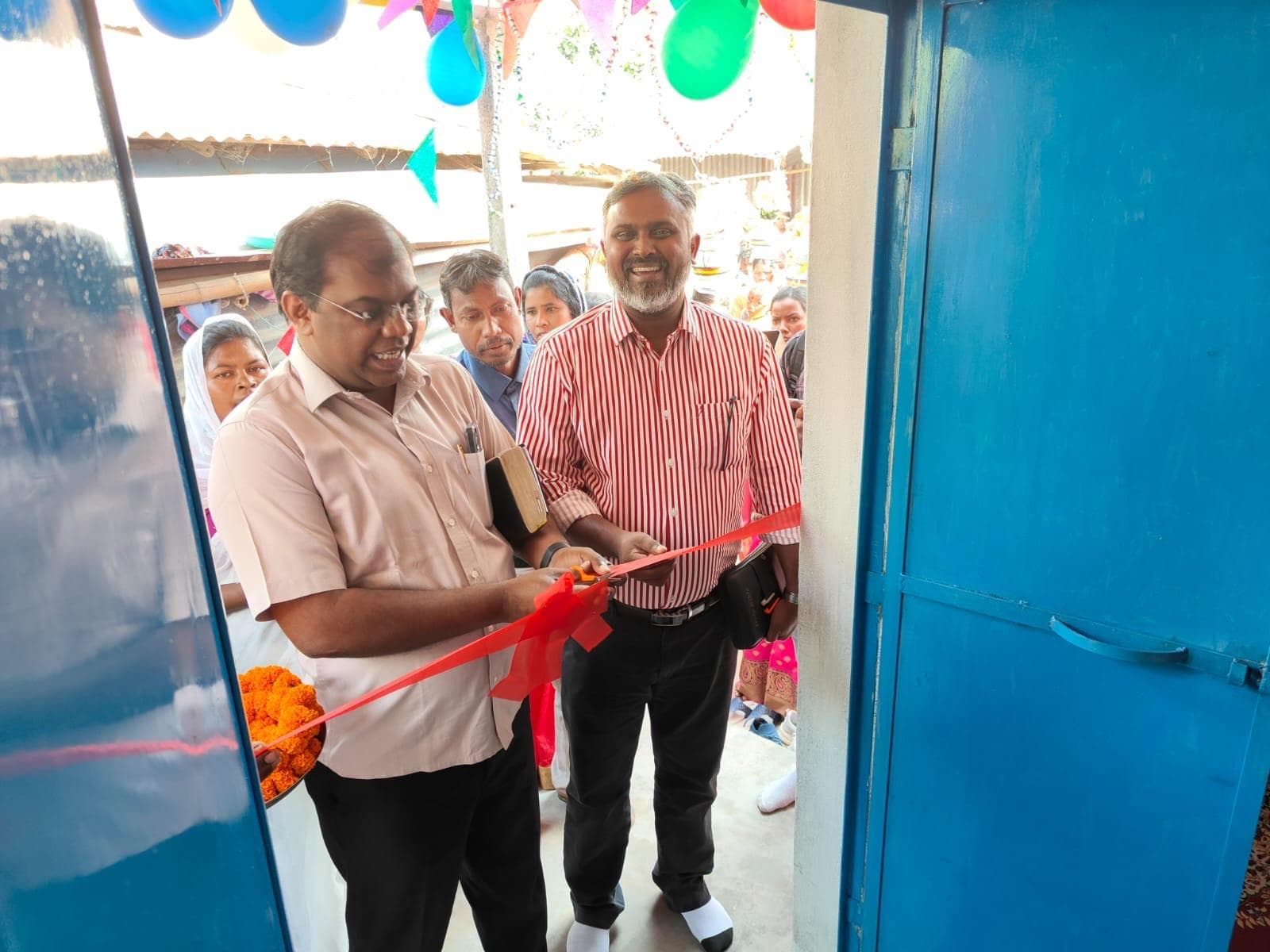 The ribbon being cut at the door of a newly built church.